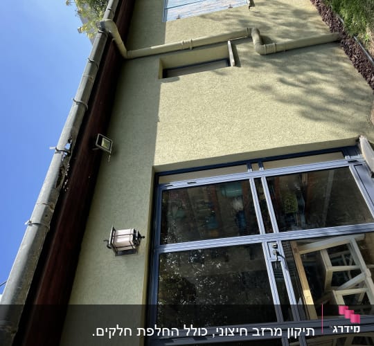 צינור מרזב על גג הבית עם קיר חיצוני